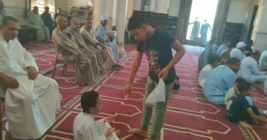 طفل يوزع الحلوى احتفالا بقدوم المولد النبوى فى مسجد العتيق جنوب الأقصر.. صور