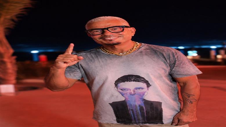 سر الصورة الغامضة على تيشيرت عمرو دياب في الساحل.. من صاحبة اللوحة؟